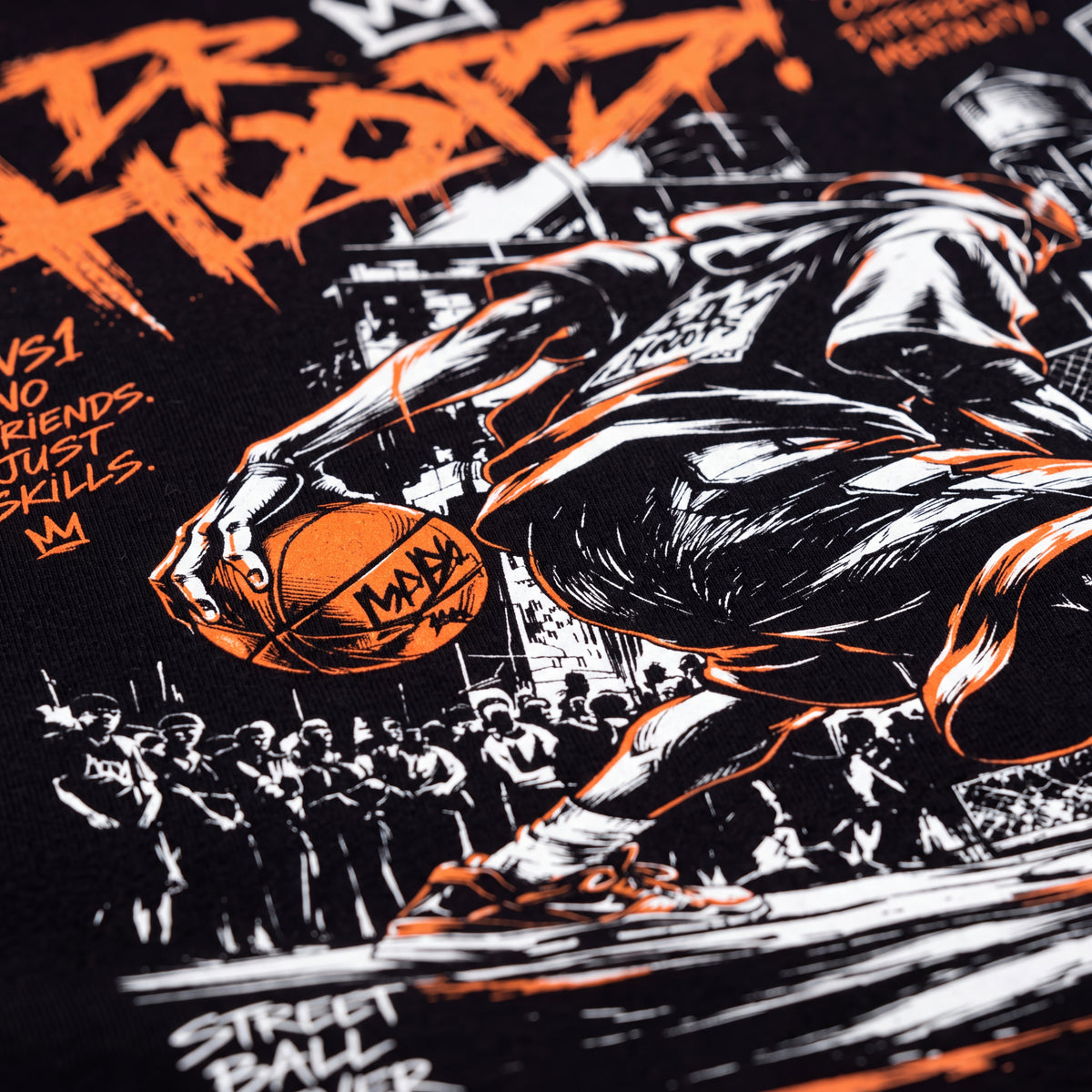 Close-up of a black graphic t-shirt featuring a stylized basketball player in black and white with bright orange accents, holding an orange basketball. The design includes street-style typography and a crowd illustration.